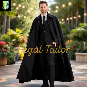 May include: A man in a black suit and cape stands outdoors. The cape is long and flowing, covering the shoulders and upper body. The suit includes a black jacket, pants, and a tie. The text "Regal Tailor" is written in gold script.