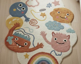 Puede incluir: Una alfombra de color blanco roto con forma de nube, decorada con monstruos de dibujos animados coloridos, nubes, estrellas y un arcoíris. La alfombra tiene una superficie texturizada y está diseñada para una habitación infantil.