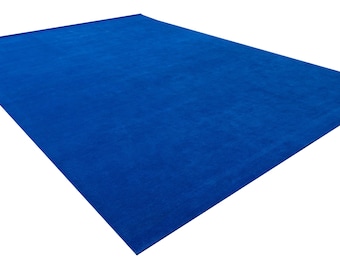 May include: A solid blue rectangular rug. The rug is made of a soft, plush material.