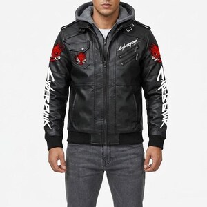 K&ouml;nnte beinhalten: Eine schwarze Kunstlederjacke mit grauer Kapuze, verziert mit roten Oni-Masken-Aufn&auml;hern an Schultern und Brust. Die &Auml;rmel und die Brust zeigen wei&szlig;e Cyberpunk-Textgrafiken. Die Jacke verf&uuml;gt &uuml;ber einen Frontrei&szlig;verschluss und Rippb&uuml;ndchen.