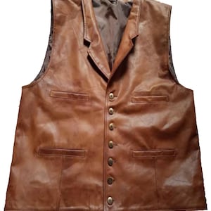 May include: A brown leather vest with a notched collar and four pockets. The vest has a button-up front with six gold-colored buttons. The vest is sleeveless and has a brown interior lining.