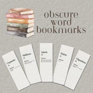 May include: A stack of watercolor books sits above five white rectangular bookmarks, each featuring a dictionary-style definition for the words Crepuscular, Mellifluous, Aphotic, Whilom, and Filipendulous, with the text obscure word bookmarks.
