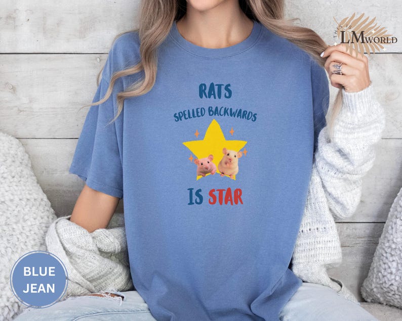 May include: Blue jean-colored t-shirt with the text "RATS SPELLED BACKWARDS IS STAR" above a yellow star graphic with two cartoon rats. The shirt is a comfortable, casual style.