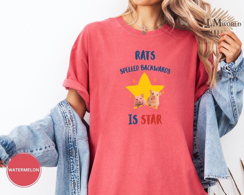 May include: A red t-shirt with the text "RATS SPELLED BACKWARDS IS STAR" in blue and red. The shirt features a yellow star graphic with two small rat illustrations. The shirt is a solid red color.
