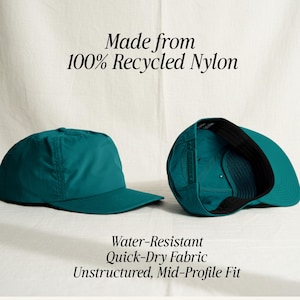 May include: A teal baseball cap made from 100% recycled nylon. The cap features an unstructured, mid-profile fit with water-resistant, quick-dry fabric. The text reads: Made from 100% Recycled Nylon. Water-Resistant. Quick-Dry Fabric. Unstructured, Mid-Profile Fit.