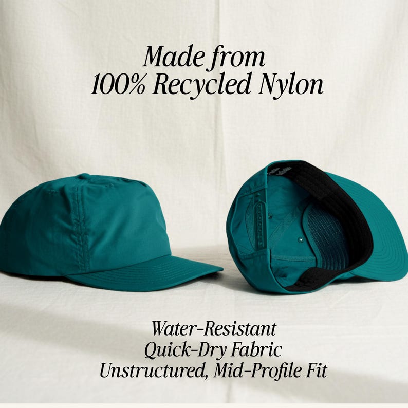 May include: A teal baseball cap made from 100% recycled nylon. The cap features an unstructured, mid-profile fit with water-resistant, quick-dry fabric. The text reads: Made from 100% Recycled Nylon. Water-Resistant. Quick-Dry Fabric. Unstructured, Mid-Profile Fit.