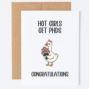May include: A white greeting card with a brown envelope featuring a cartoon goose wearing a pink bow and holding a bouquet of pink roses. The text reads HOT GIRLS GET PHDS and CONGRATULATIONS in black sans-serif font on the front of the card.