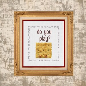 May include: Cross stitch pattern featuring a saltine cracker with the text "FIND THE SALTINE do you play? FIND THE SALTINE" repeated on the sides.