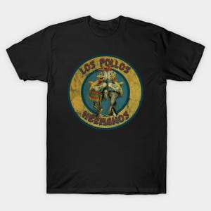 Peut inclure: T-shirt noir avec un motif circulaire portant l'inscription "LOS POLLOS HERMANOS". Le motif représente deux poulets de dessin animé en tabliers et chapeaux. Le design a un aspect vintage et vieilli.