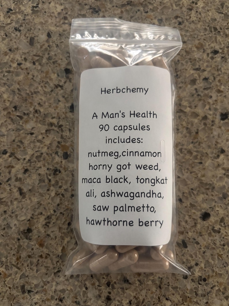 Peut inclure: Un sac en plastique transparent rempli de g&eacute;lules marron. Une &eacute;tiquette blanche indique : "Herbchemy, A Man's Health, 90 capsules includes: nutmeg, cinnamon, horny got weed, maca black, tongkat ali, ashwagandha, saw palmetto, hawthorne berry."