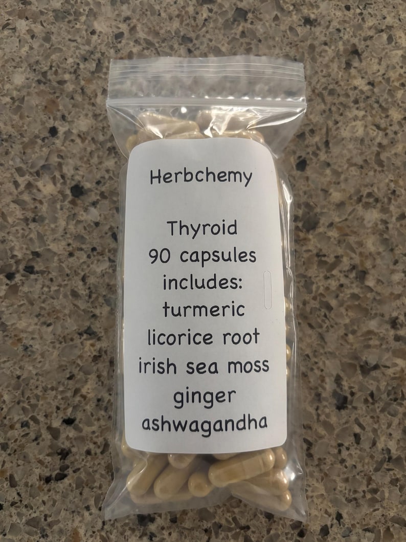 May include: A clear plastic bag filled with beige capsules. A white label on the bag reads "Herbchemy Thyroid 90 capsules includes: turmeric, licorice root, irish sea moss, ginger, ashwagandha."