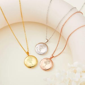 Könnte beinhalten: Drei Halsketten aus Gold, Silber und Roségold mit zarten Ketten und runden Anhängern. Jeder Anhänger zeigt ein Blumenmuster und eine Inschrift. Die Anhänger tragen die Inschriften "Forever", "Always" und "Truly".