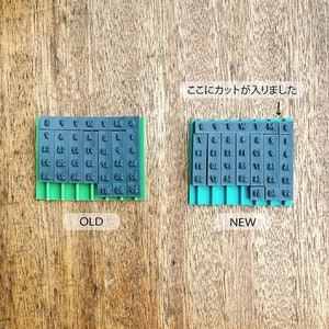 May include: A comparison of two date stamp sets, one labeled "OLD" and the other labeled "NEW". The "NEW" set has a cut-out section, indicated by the Japanese text "ここにカットが入りました" (Here is the cut).