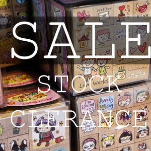 May include: A display of various sticker sets with cartoon illustrations. The word "SALE", "STOCK", and "CLEARANCE" are overlaid on the image. The stickers feature cute characters, hearts, and other decorative elements.