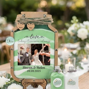 May include: A wooden wedding sand ceremony set. The frame is shaped like a jar, with a photo of a couple and the text "love today tomorrow always". Includes two small bottles and a wooden stand. The date "09.09.2025" is also visible.