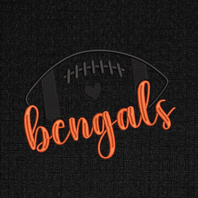 Puede incluir: Un dise&ntilde;o bordado sobre un fondo negro presenta un bal&oacute;n de f&uacute;tbol naranja con la palabra "Bengals" en cursiva. Un peque&ntilde;o coraz&oacute;n negro est&aacute; en el centro del bal&oacute;n.
