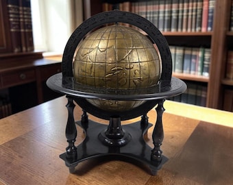 May include: A brass globe featuring engraved continental outlines and grid lines, mounted within a dark brown wooden frame. The globe is supported by a four-legged stand with a circular base and a curved meridian ring marked with degree increments.