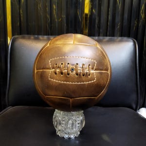 Könnte beinhalten: Ein handgemachtes Holzschneidebrett mit natürlicher Holzmaserung. Das Brett ist rechteckig mit einem abgerundeten Griff und misst ca. 45 cm lang und 30 cm breit.