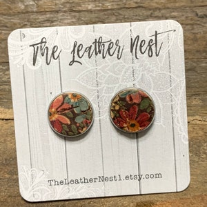 May include: A pair of earrings with a floral print on a white card with the text "The Leather Nest" and "TheLeatherNest.etsy.com".
