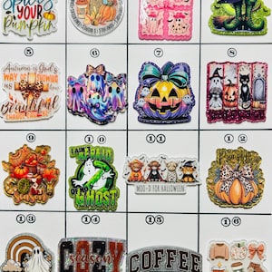 May include: A collection of sixteen fall and Halloween-themed acrylic charms. Designs include pumpkins, ghosts, witches, and phrases like "Whatever Spices Your Pumpkin" and "Ain't No Holla Back Ghoul."