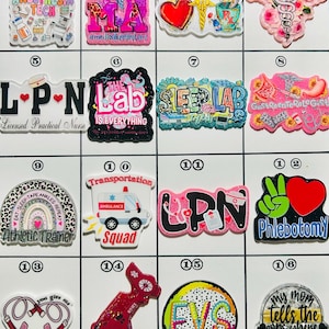 May include: A collection of colorful pins with various medical and healthcare-related themes. Designs include "Anesthesia Tech," "MA," "Pharmacist," "LPN," "The Lab," "Sleep Lab," "Athletic Trainer," and "Phlebotomy."