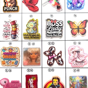 May include: A white ceramic mug with a black handle and the text "But First, Coffee" in a black, handwritten-style font. The mug is on a white surface.