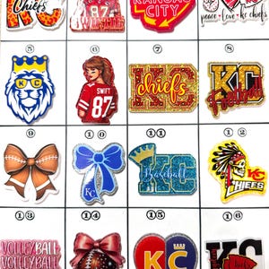 May include: A collection of decorative charms featuring various designs. These include the words "Chiefs", "Kansas City", and "Football", along with images of a lion, a football, a bow, and a heart. Some charms have the number "87" and the name "Swift".
