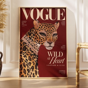 May include: A vertical wall art print featuring a magazine cover design with the title VOGUE in large cream letters. The artwork displays a leopard wearing multiple strands of pearl necklaces against a deep red background with the text WILD AT HEART.