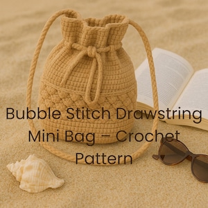 以下が含まれることがあります： ベージュ色の巾着クロシェミニバッグ。バブルステッチ模様で、肩紐が付いています。画像には「Bubble Stitch Drawstring Mini Bag - Crochet Pattern」と書かれています。貝殻、サングラス、開いた本も写っています。