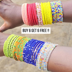 May include: A collection of colorful beaded bracelets in various shades of pink, red, yellow, blue, green, and white. The bracelets are stacked on wrists, showcasing a variety of patterns and designs. The text "BUY 6 GET 6 FREE !!" is displayed.