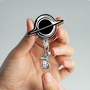 Bobine de badge spatial amusante avec breloque astronaute, porte-carte d'identité rétractable design planète noire pour infirmières, techniciens, enseignants, bobine de badge cadeau galaxie