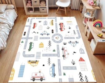 May include: A white play mat with a road map design featuring cars, buildings, trees, and traffic signals. The mat includes a police car, ambulance, and taxi. The design is in shades of gray, red, yellow, green, and blue.