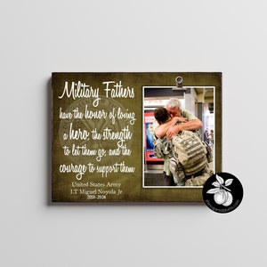 Puede incluir: Un letrero de madera verde con una foto de un padre y un hijo abrazándose. El letrero tiene el texto "Military Fathers have the honor of loving a hero, the strength to let them go, and the courage to support them. United States Army LT Miguel Noyola Jr 2018-2024"