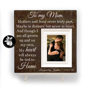 May include: A brown wooden picture frame with a white mat and a photo of a mother and son dancing. The frame has a quote that reads "To my Mom, Mothers and Sons never truly part, Maybe in distance but never in heart. And though I am all grown up and on my own, My heart will always be tied to Home. Love your boy, Jonathan ~11/23/20".