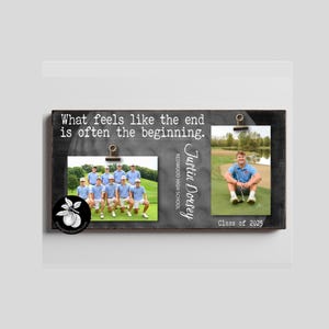 May include: A rectangular dark gray wooden photo display board featuring the text "What feels like the end is often the beginning." It includes two metal clips holding photos, the name "Justin Dorsey," "Redwood High School," and "Class of 2025."