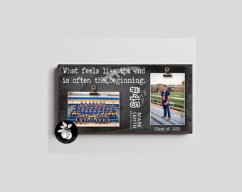 May include: A rectangular dark wood photo display board featuring the text What feels like the end is often the beginning. It includes two metal clips holding a team photo and a portrait of a football player with the text #45 MARK SMITH CLASS OF 2025.