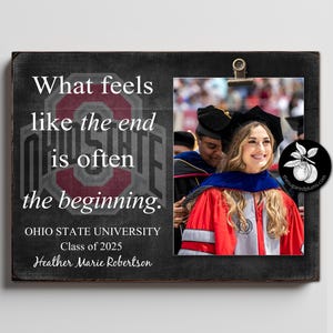May include: A black and white graduation photo frame with a quote that reads "What feels like the end is often the beginning." The frame has a red and white Ohio State University logo and the text "Ohio State University Class of 2025 Heather Marie Robertson".