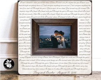 May include: A square wooden sign with a dark brown frame surrounding a central photograph of a couple embracing. The white background is filled with black cursive lyrics, and the bottom displays the text Tony and Brooke - August 17, 2016.