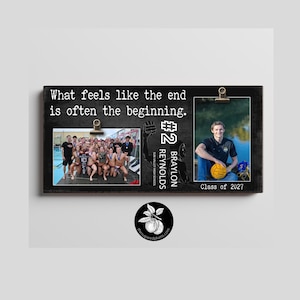 May include: A rectangular black wooden photo display board featuring the text What feels like the end is often the beginning. It includes two metal clips for holding photos, a silhouette of a water polo player, the number 2, and the text Braylon Reynolds Sun Valley High School Class of 2027.