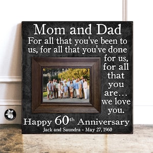 May include: A black and gray canvas print with a photo of a family in front of a lake. The text reads "Mom and Dad For all that you've been to us, for all that you've done for us, for all that you are... we love you. Happy 60th Anniversary Jack and Saundra - May 27, 1960"