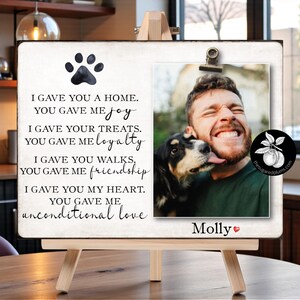 May include: A wooden easel with a framed photo and text. The photo shows a person with a dog. Text includes "I gave you a home, you gave me joy" and "Molly" with a heart symbol. A paw print is at the top.