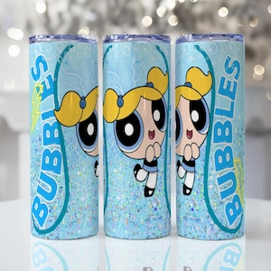Peut inclure: Trois gobelets bleu clair avec le mot "Bubbles" en bleu et un éclair jaune. Chaque gobelet présente une image de dessin animé d'une fille blonde avec un contour noir. Les gobelets ont un effet scintillant.
