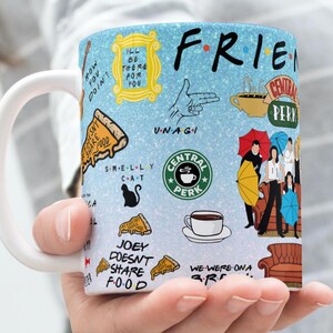 Puede incluir: Una taza de cerámica blanca con un fondo azul claro y varias ilustraciones y texto de la serie de televisión "Friends". La taza presenta el logotipo del programa, Central Perk, y otras imágenes icónicas.