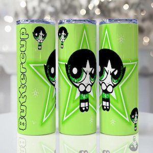 Puede incluir: Tres vasos verdes con el personaje de Pétalo de Las Supernenas. Cada vaso tiene un fondo verde lima con una estrella blanca y la imagen de Pétalo. La palabra "Buttercup" está impresa verticalmente en un vaso.