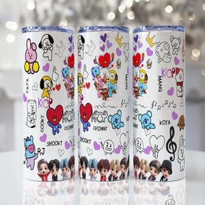 May include: Three white cylindrical tumblers featuring a repeating pattern of colorful cartoon characters, purple hearts, crowns, musical notes, and the text KPOP, CHIMMY, TATA, COOKY, RJ, SHOOKY, KOYA, and MANG, with a row of small human figures at the base.