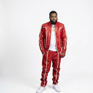 Puede incluir: Un ch&aacute;ndal de cuero rojo con ribetes blancos. La chaqueta, de estilo bomber, se lleva sobre una camiseta blanca. Los pantalones a juego tienen un dise&ntilde;o de pernera recta. Zapatillas blancas completan el conjunto.