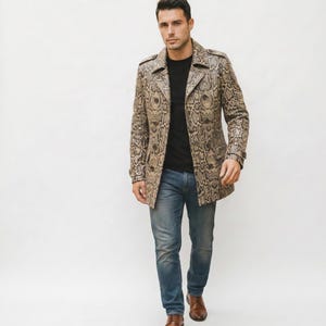 May include: A tan and brown snakeskin-patterned trench coat with a notched collar and button closure. The coat is worn over a black shirt and blue jeans. Brown leather shoes complete the outfit. The coat is a statement piece.
