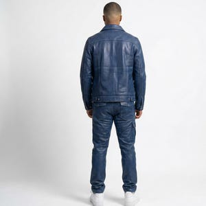 May include: A blue leather jacket and matching jeans. The jacket has a classic collar and button closure. The jeans have cargo pockets. The outfit is a solid blue color.