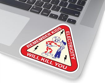 Peut inclure: Un autocollant triangulaire avec une bordure rouge et le texte "REMEMBER KIDS ELECTRICITY WILL KILL YOU." L'autocollant présente une illustration de dessin animé d'une figure électrocutant une autre. L'autocollant est sur un ordinateur portable.