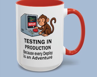 May include: A white ceramic mug with a red interior and handle. The front features a cartoon monkey pressing a red button on a computer console. Text reads: TESTING IN PRODUCTION Because every Deploy is an Adventure. The design is colourful and clear.